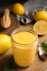 Delicious lemon curd and fresh fruits on wooden table