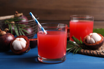 Delicious fresh mangosteen juice on blue wooden table