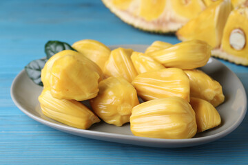 Delicious exotic jackfruit bulbs on light blue wooden table