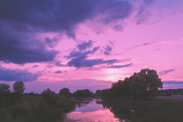 Magical pink sunset over the lake. Serene lake in the evening. Nature landscape