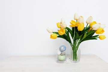 Yellow tulips in a vase and Easter eggs Copy Space