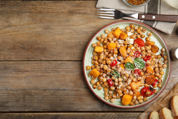 Delicious fresh chickpea salad served on wooden table, flat lay. Space for text