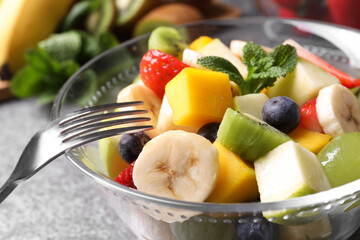 Delicious fresh fruit salad in bowl on table, closeup
