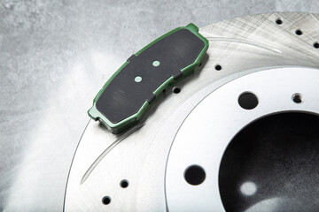 brake pads and perforated brake discs on a stone gray table