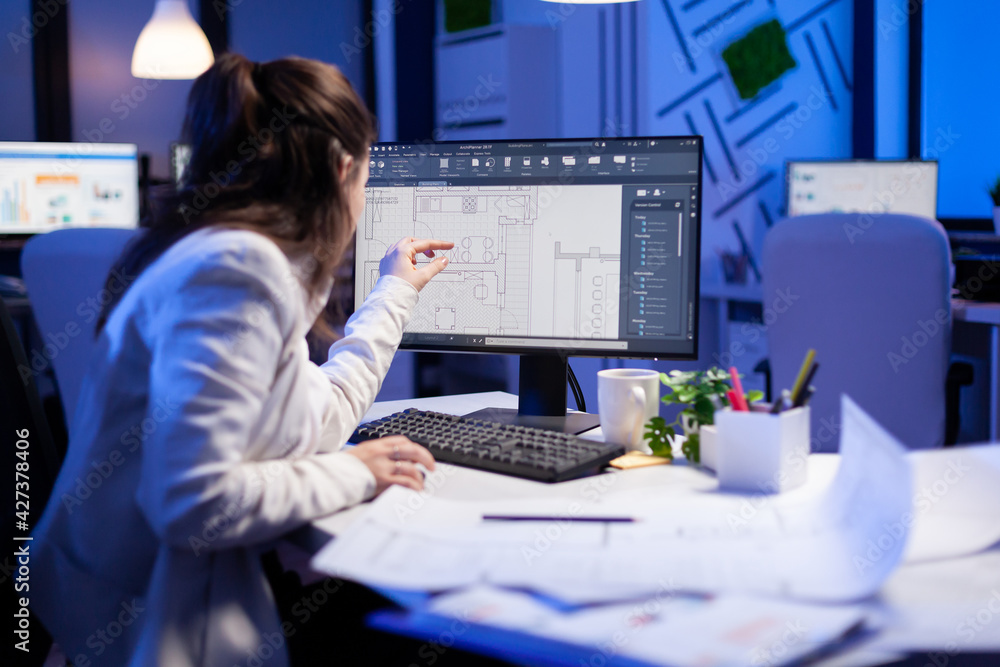 Poster over the shoulder shot of engineer woman drawing architectural plans and looking at cad software on 