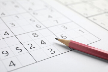 Sudoku puzzle grid and pencil, closeup view