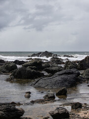 Rock formation under the cloudy sky at Flynns Beach, Port Macquarie, Australia.