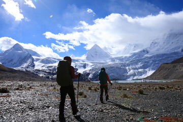 Fototapeta premium Two women hikers hiking in winter high altitude mountains