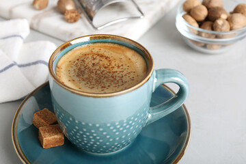Coffee with nutmeg powder and brown sugar on light grey table, closeup