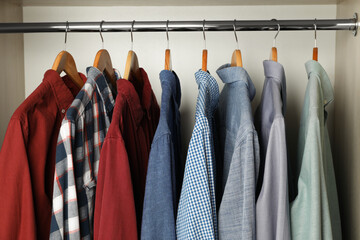 Hangers with clothes on rack in wardrobe