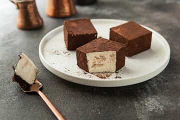 vanilla soufflé in chocolate on a round stylish plate.
square pieces of bird milk cake.