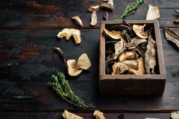 Dried mushrooms, on old dark  wooden table background , with space for text  copyspace