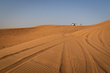Desert safari tour in UAE. Four wheel drive desert safari car on a san dune with a tourists - 427380480