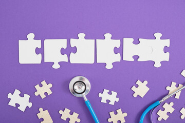 Naklejka premium medical stethoscope, puzzles, dominoes, paints, glasses, educational toys on a purple background top view, the inscription autism on puzzles