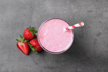 Delicious strawberry drink on grey table, flat lay