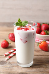 Delicious drink with strawberries on wooden table
