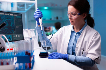 Scientist using micropipette to take sample to analyse it in medicine healthcare laboratory. Woman...