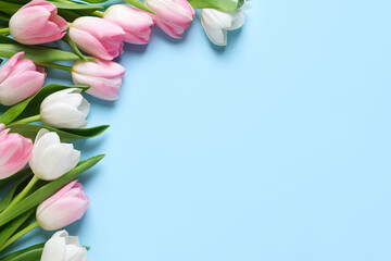 Beautiful pink spring tulips on light blue background, flat lay. Space for text
