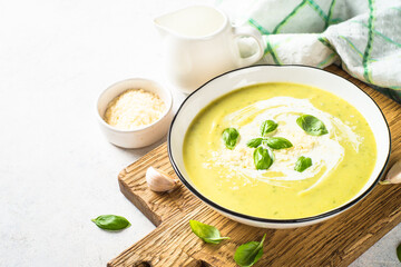 Zucchini soup with spinach and herbs at white.