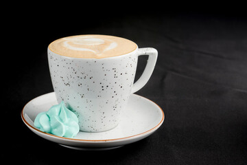 Cup of caramel latte coffee on black background. Delicious sweet sugar coffee
