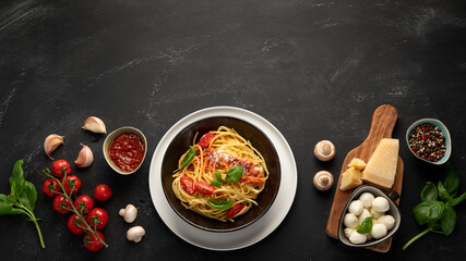 Assortment of Italian pasta with traditional sauces for dinner on dark background.