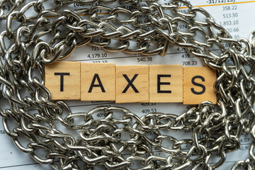 tax word on wood block with concept of taxes