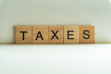 tax word on wood block with concept of taxes