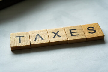 tax word on wood block with concept of taxes