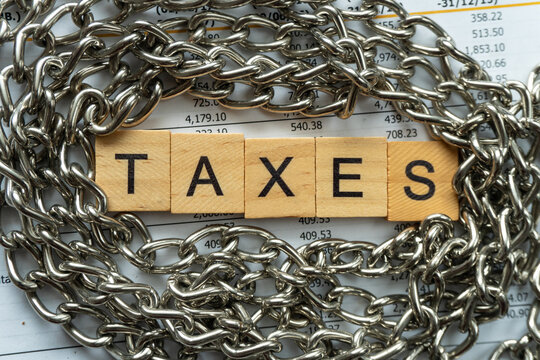 tax word on wood block with concept of taxes