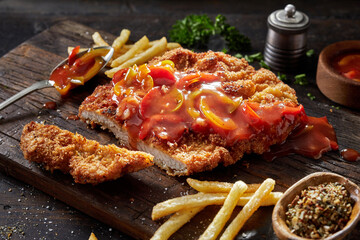 Appetizing schnitzel with pepper sauce and fries