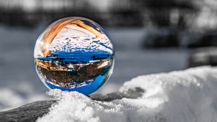 Fototapeta na wymiar Crystal ball alpine landscape with background outside the sphere and details of snow crystals at the famous Hintersee with the Reiteralpe in the background at Ramsau, Berchtesgaden, Bavaria, Germany