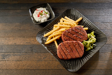 Vegetarian steak with fries and sauce