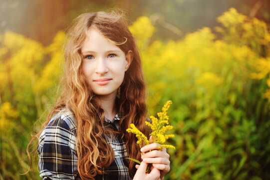 preteen 11 years old kid girl walking on summer countryside road, enjoying vacations outdoor