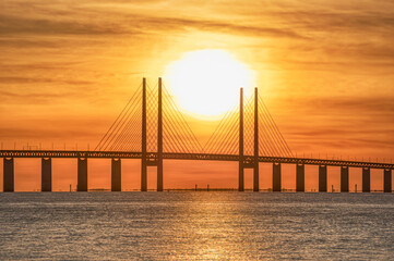 Fototapeta na wymiar Oresund Bridge sunset in the Baltic sea, detail of the central pylons with cables. The link or connection between Copenhagen and Malmo was built to close the gap in Scandinavian or Nordic countries