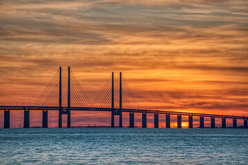 Oresundsbron (Oresund Bridge) sunset provides illustration of political or cultural unity between the Scandinavian countries of Sweden and Denmark as commuters travel between the international borders