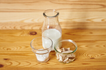 Dough starter ingredients in transparent glasses on brown wooden background. Fresh wild yeast, milk and sugar as dough ingredients concept. High quality photo
