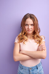 Dissatisfied offended young caucasian girl isolated on purple background studio portrait