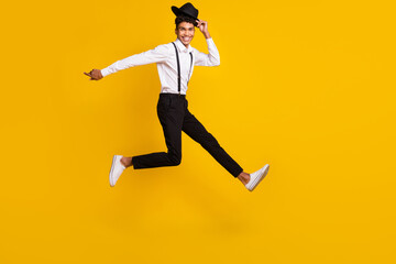 Fototapeta na wymiar Full length photo portrait of african american man running taking off hat jumping up isolated on vivid yellow colored background