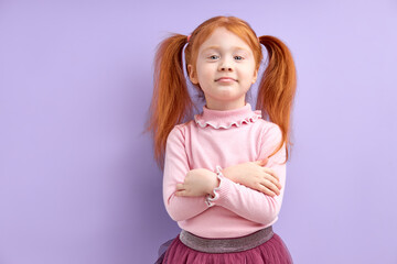 human emotions, reactions and feelings. moody displeased little girl crossing arms on her chest, having offended facial expression