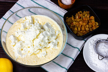 Glass bowl with batter and homemade cottage cheese. The process of making curd dough. Dough for cottage cheese pancakes.