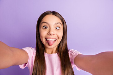 Photo of young girl happy positive smile grimace tongue-out make selfie isolated over purple color background