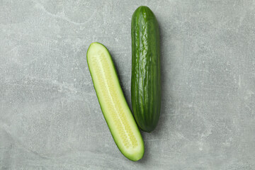 Ripe cucumbers on gray background, space for text
