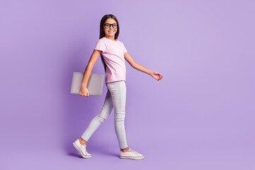 Fototapeta na wymiar Full size profile photo of optimistic nice brunette girl hold laptop go wear spectacles t-shirt isolated on purple background