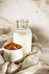 Vegan almond milk with almond on a marble table.Alternative dairy.Rustic food photography.Still...