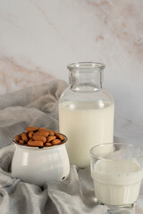 Vegan almond milk in bottle with almond  and glass of milk on a marble table.Alternative dairy.Rustic food photography.Still life.
