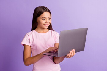 Photo of optimistic nice brunette girl look laptop wear t-shirt isolated on purple color background