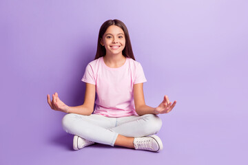 Photo of peaceful sweet young girl wear pink t-shirt sitting floor practicing yoga isolated violet color background