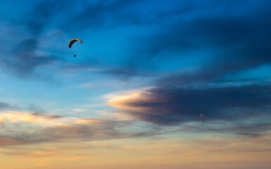 Paraglider flying in the beautiful sky against the background of clouds.