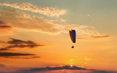 Paraglider flying in the beautiful sky against the background of clouds.
