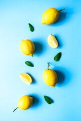 Flat lay von frischen Zitronen und Pfefferminz Blätter auf einem blauen Hintergrund. Sommer, Vitamin C.